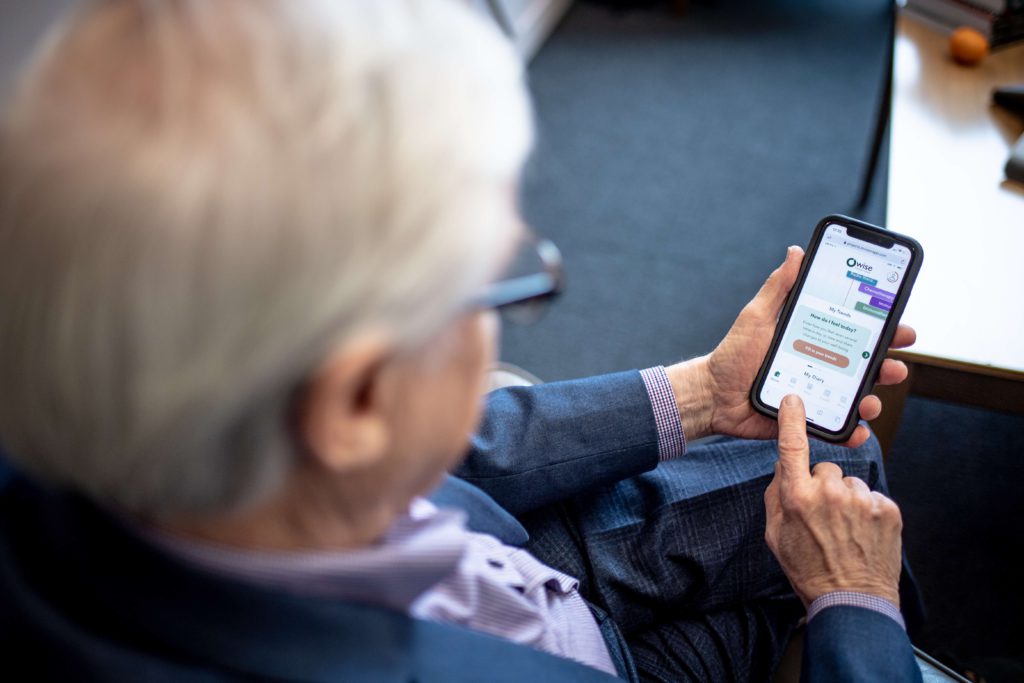 Older man trials OWise prostate cancer app on his smartphone.